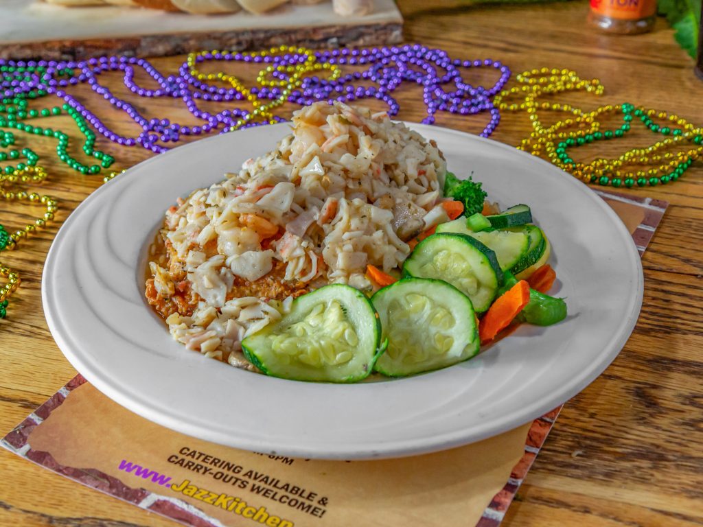 Jazz - A Louisiana Kitchen A plate of rice with seafood and sliced vegetables. Decorative beads are scattered around the table. Kansas City, Columbia