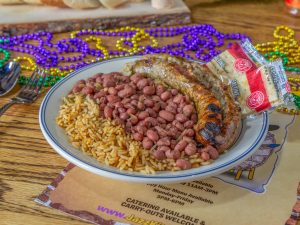 Jazz - A Louisiana Kitchen A plate of rice and beans with sausages, garnished with crackers, on a table decorated with colorful beads. Kansas City, Columbia