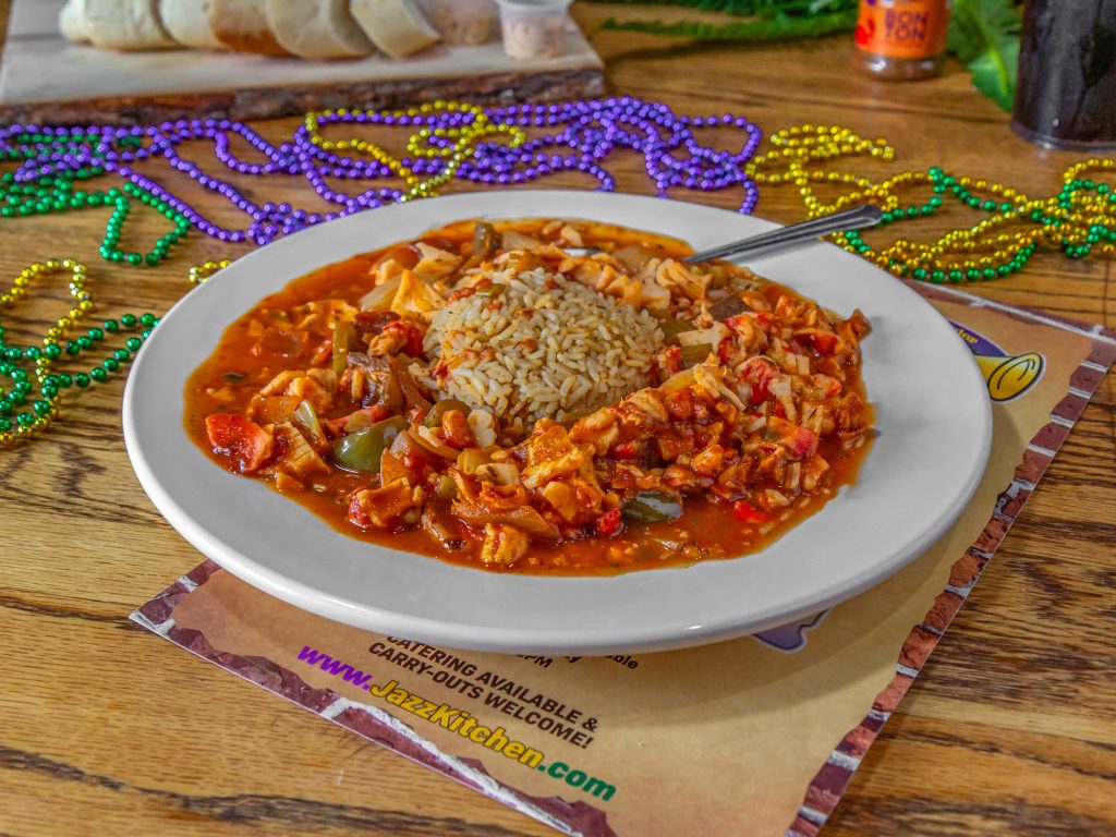 Jazz - A Louisiana Kitchen Plate of jambalaya with rice and colorful beads on a wooden table. Kansas City, Columbia
