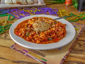 Jazz - A Louisiana Kitchen Plate of jambalaya with rice and colorful beads on a wooden table. Kansas City, Columbia